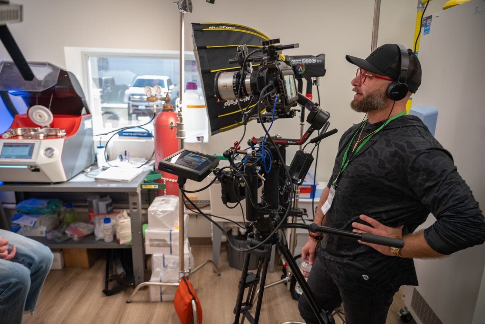 A crew member in headphones behind a cinema camera in a workshop