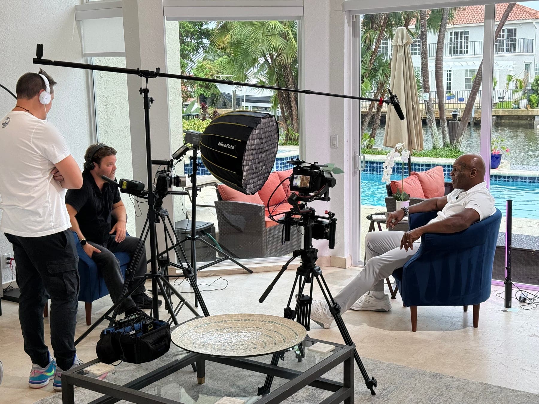 Camera, boom and lighting set for a seated interview in a waterfront living room